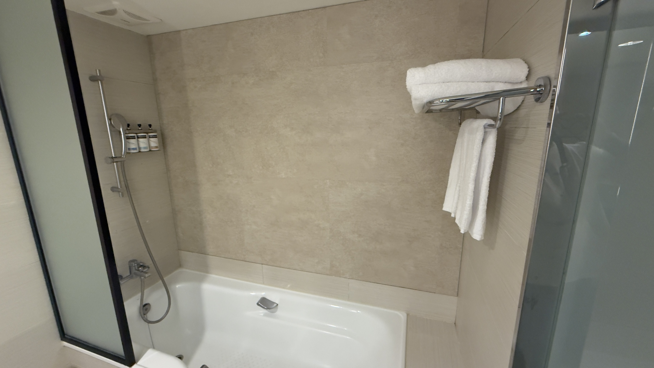 台北車站智選假日酒店Holiday Inn Express實住心得 18 蓮蓬頭和浴缸是在一起的,乾濕分離也是半開放式,所以如果洗澡一定還是會噴到浴缸外頭,這個區塊沒有燈光,所以整間浴室是偏暗的。而這家酒店因為是貼牌,所以門不像中部和嘉義的智選假日使用一門兩用的設計,這點我是蠻喜歡的。